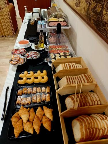 a buffet line with different types of bread and pastries at Carlos V Malaga in Málaga