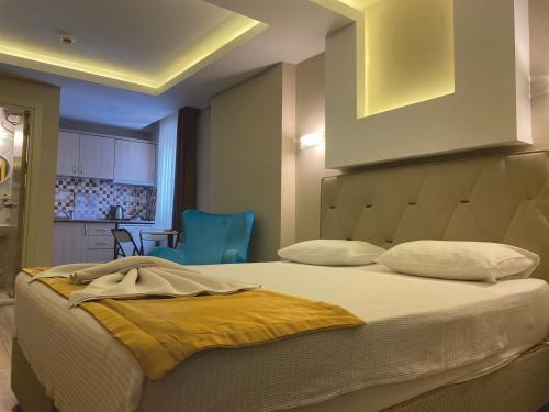 a bedroom with a bed with a yellow blanket on it at Arya Otel in Marmaris