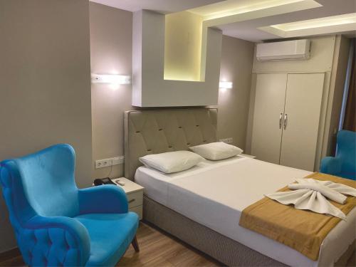 a bedroom with a bed and a blue chair at Arya Otel in Marmaris