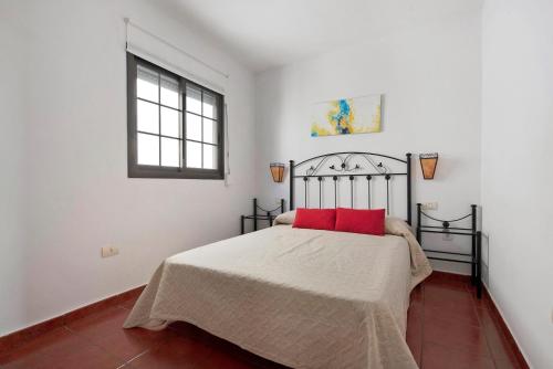 a bedroom with a bed with red pillows on it at Ático El Agua in Santiago del Teide