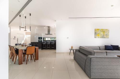 a living room and dining room with a couch and a table at Beachfront Luxury Villa Glory in Ayia Napa