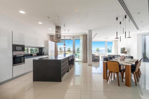 a kitchen and dining room with a table and chairs at Vivo Mare Beachfront-Seaview Villas in Ayia Napa