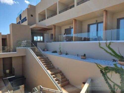 an external view of a building with stairs and plants at Meliti Hotel (Adults Only) in Agios Nikolaos