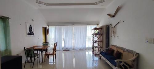 a living room with a blue couch and a table at J-House, spacious apartments with balconies, Thalassa 1min away in Siolim