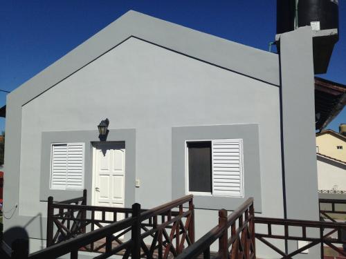a small white house with a porch at La Posada de Damian in San Clemente del Tuyú