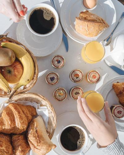 a table with plates of food and cups of coffee at Hotel de L'Universite in Paris