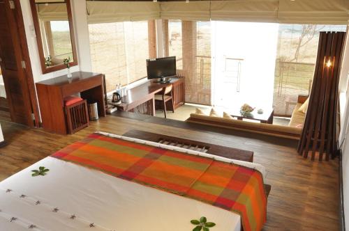 a bedroom with a bed and a living room at Laya Safari Resorts & Spa in Yala