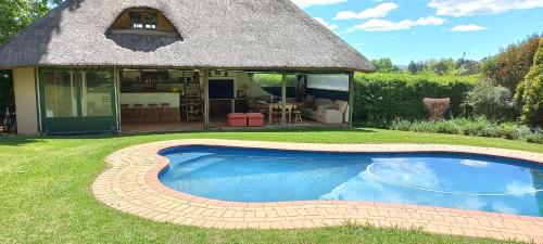 a small swimming pool in front of a house at Rosedale Self Catering Cottage with pool and large entertainment BBQ area in Henburg Park