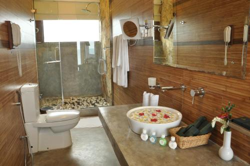 a bathroom with a toilet and a shower and a sink at Laya Safari Resorts & Spa in Yala