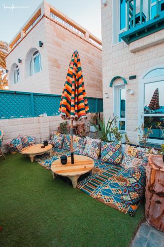 a patio with a table and a couch and an umbrella at Skyrock Dahab in Dahab