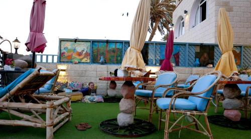a patio with chairs and tables and umbrellas at Skyrock Dahab in Dahab