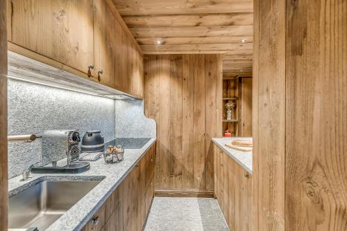 a kitchen with wooden walls and counters and a sink at Hotel & Spa Le Val d'Isère in Val dʼIsère