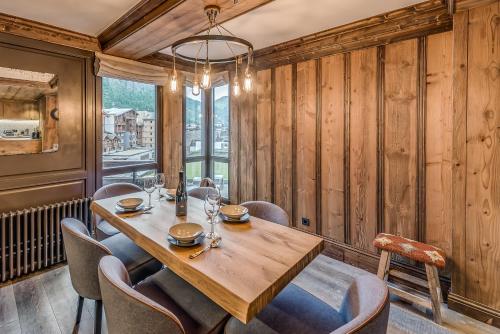 a dining room with a wooden table and chairs at Hotel & Spa Le Val d'Isère in Val dʼIsère
