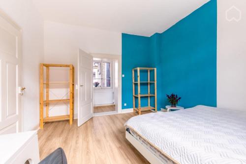 - une chambre avec un lit et un mur bleu dans l'établissement Historic 4 Rooms, à Mannheim