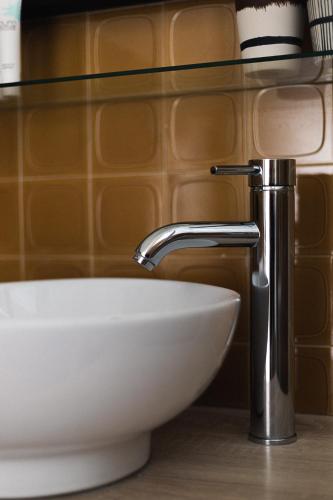 un lavabo blanc dans une salle de bain avec un robinet dans l'établissement Les Cèdres - Hôtel - Restaurants - Spa, à Saint-Sorlin-dʼArves