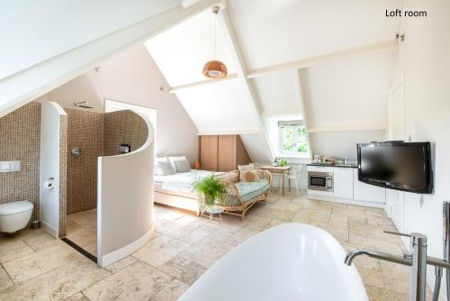 ein Badezimmer mit einem Waschbecken und ein Wohnzimmer in der Unterkunft Boutique hotel Villa Oldenhoff in Abcoude