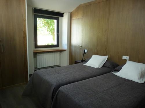 a hotel room with two beds and a window at A casa do viveiro in Dormeá