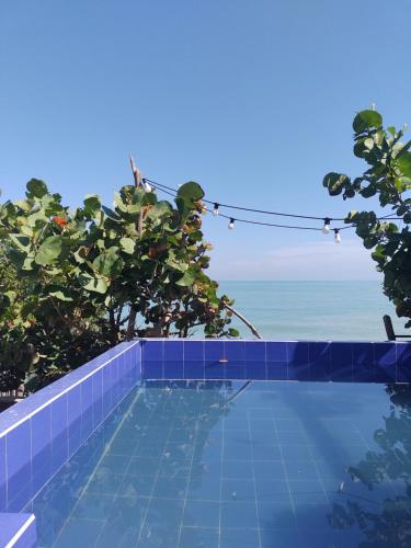 a swimming pool with a view of the ocean at Playa Kai Glamping in La Punta de los Remedios