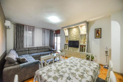 Apartman Vukcevic في بودغوريتسا: غرفة معيشة فيها أريكة وسرير