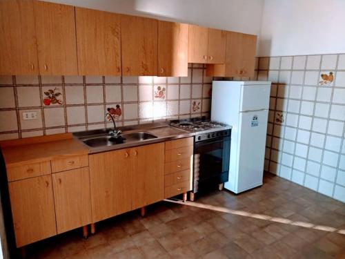 a kitchen with a stove and a refrigerator at Casa Centineo in Barcellona-Pozzo di Gotto