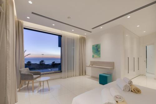 a bedroom with a bed and a large window at Beachfront Luxury Villa Glory in Ayia Napa