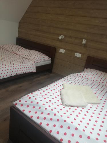 two beds with polka dots on them in a room at Drevenica pod Lánom in Zuberec
