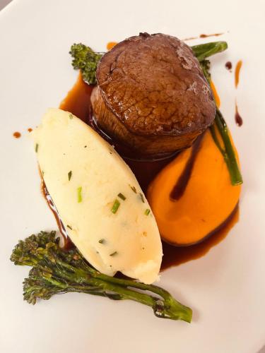 a plate of food with a piece of meat and vegetables at Nuthurst Grange Country House Hotel & Restaurant in Solihull