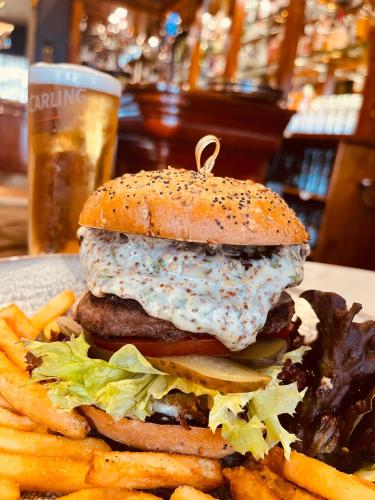 a hamburger and french fries and a glass of beer at Nuthurst Grange Country House Hotel & Restaurant in Solihull