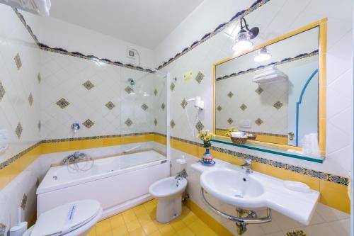 a bathroom with a tub and a sink and a toilet at Riviera B&B Rooms in Maiori