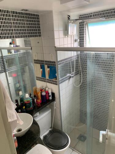um banheiro com chuveiro, vaso sanitário e pia em Ape em Maceió em Maceió