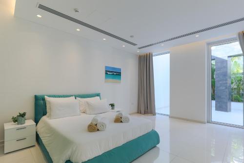 a white bedroom with a large bed with white pillows at Beachfront Luxury Villa Glory in Ayia Napa
