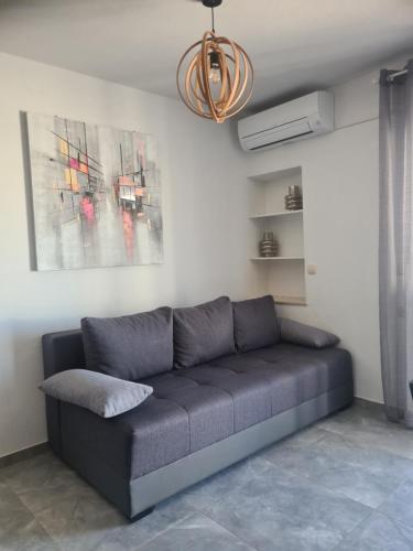 a couch in a living room with a painting at Hello Sunshine - Apartment on the Beach in Zubovići