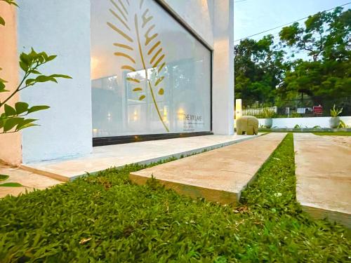 une maison moderne avec une pelouse verte en face de celle-ci dans l'établissement The Ivy Lake, à Anurâdhapura