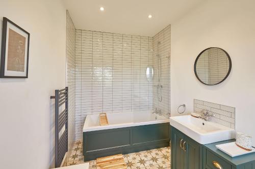 a bathroom with a tub and a sink at Wold's View Cottage in Yedingham