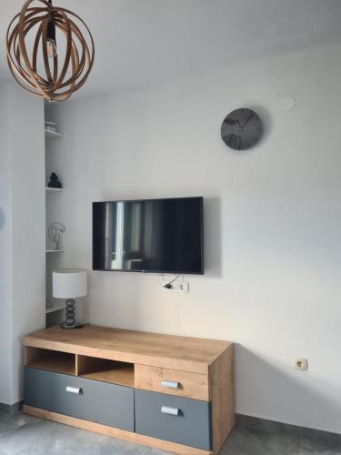 ein Wohnzimmer mit einem TV an einer weißen Wand in der Unterkunft Hello Sunshine - Apartment on the Beach in Zubovići