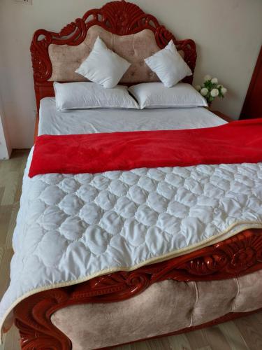a large bed with a red and white comforter at Nepal christian guest house in Pātan