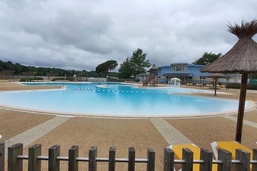 una gran piscina azul con sillas y sombrilla en CAMAT T1 de plain pied à la campagne, en Cazaubon
