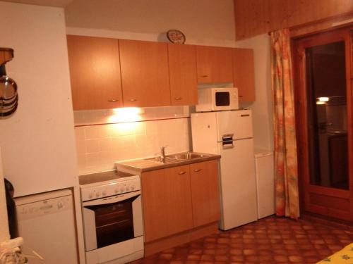 une cuisine avec un réfrigérateur blanc et un évier dans l'établissement croix du Sud, à Valloire