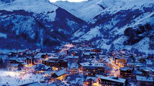 une ville dans la neige avec des montagnes en arrière-plan dans l'établissement croix du Sud, à Valloire