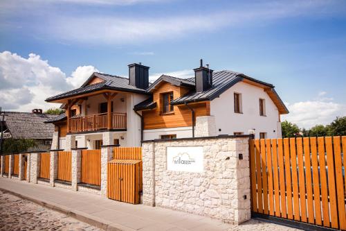 a house behind a wooden fence with a gate at Willa Kazimierz Dolny in Kazimierz Dolny