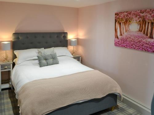 a bedroom with a bed with a painting on the wall at The Old Telephone Exchange in Rothbury