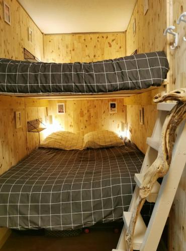 - une chambre avec des lits superposés dans un mur en bois dans l'établissement Gourette appartement près des pistes, Résidence Val Soleil, 256 Gourette Nord, rue de Tortes, à Eaux-Bonnes