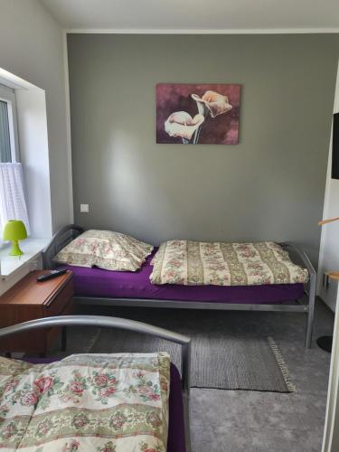 a room with two beds and a painting on the wall at Ferienwohnung Markranstädt in Markranstädt