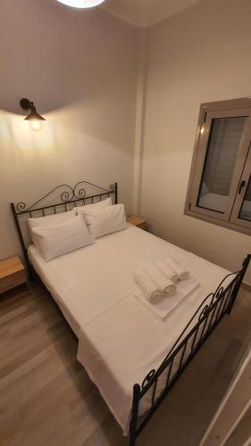 a bed with white sheets and white pillows on it at Larry's little place in the center of Gytheio in Gythio