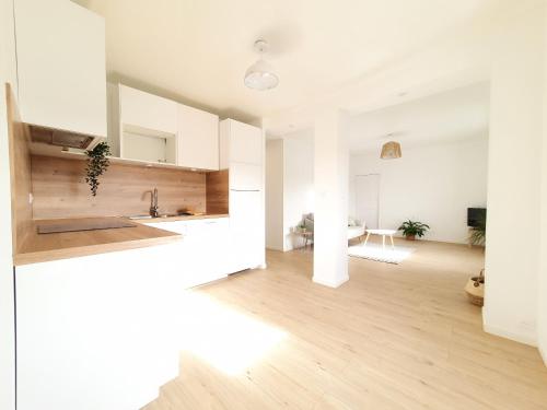 uma cozinha com paredes brancas e piso em madeira em Quiet & Cosy near Loire River & Tramway em Nantes
