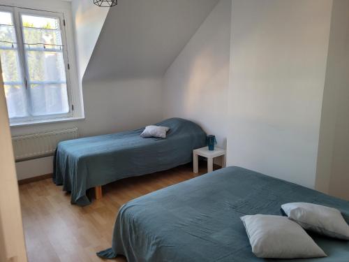 twee bedden in een kleine kamer met een raam bij Bléré maison centre ville proche Beauval et Chenonceau in Bléré
