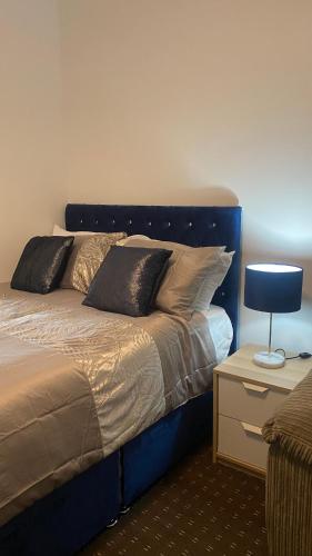 Bv Comfy Studio At Deighton Huddersfield في هدرسفيلد: سرير مع اللوح الأمامي الأزرق في الغرفة