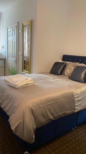 Bv Comfy Studio At Deighton Huddersfield في هدرسفيلد: سرير كبير في غرفة نوم مع مرآة