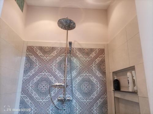 a shower in a bathroom with a tile wall at Glamping Altes Pastorat in Barmstedt