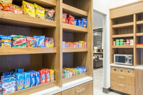 a pantry with wooden shelves filled with chips and snacks at Holiday Inn Portland West - Hillsboro by IHG in Hillsboro